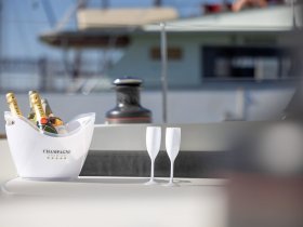 A stylish display of premium champagne and elegant glasses set on a boat, perfect for celebrating special moments on the water.