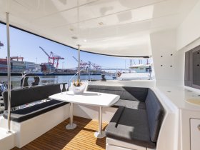 A stylish interior view of a boat's dining area featuring comfortable seating and a table, perfect for enjoying meals while cruising.