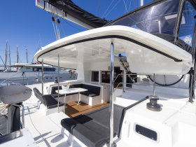A spacious and modern interior of a yacht featuring comfortable seating and a well-equipped helm, perfect for relaxing or navigating the waters.