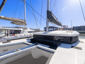 A sleek catamaran docked at the marina, showcasing its modern design and spacious deck — perfect for luxury sailing experiences.