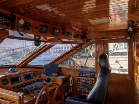 The interior helm of a boat showcases a well-equipped console with navigational instruments and a comfortable captain's chair, perfect for steering adventures on the water.