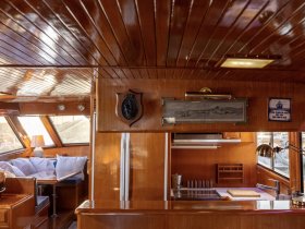 A beautifully crafted interior of a boat showcasing a cozy seating area and well-equipped helm, perfect for relaxing and navigating the waters.