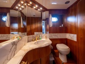 A beautifully designed boat bathroom featuring elegant marble countertops and wooden finishes, providing a luxurious touch to onboard accommodations.