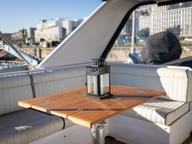 A cozy interior view of a boat's dining area featuring a wooden table and elegant seating, perfect for enjoying meals while at sea.