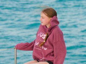 A young girl enjoys the breeze on a boat, capturing the essence of a relaxing day at sea.