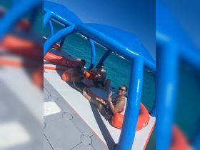 A lively group enjoys drinks on a floating mat in clear turquoise waters, perfect for a fun day out on the water.