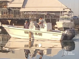 A speedboat named 'Hooked Again' is docked, reflecting beautifully in the calm waters, showcasing the serene boating atmosphere.