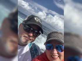 A couple enjoys a thrilling boating adventure on the open ocean, capturing the excitement of their day on the water.