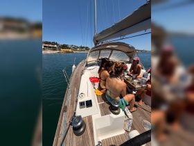 A lively group enjoys drinks and conversation aboard a yacht, perfect for summer outings and celebrations on the water.