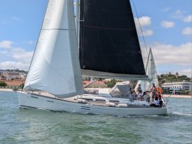 A group enjoys a sailing adventure on a beautiful day, showcasing the excitement of being on the water aboard a sleek yacht.