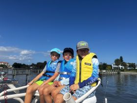Three kids enjoy a fun day on the water, showcasing the joy of fishing and boating adventures. Perfect for family outings and creating lasting memories.