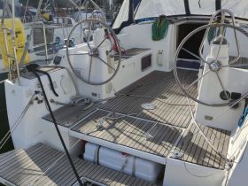 A detailed view of the helm area inside a sailboat, showcasing the steering wheel and spacious deck, perfect for navigating the open waters.