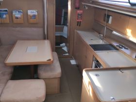 Interior view of a boat's cabin featuring a cozy dining area and kitchen setup, perfect for relaxing and enjoying meals while on the water.