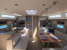 A spacious and modern interior of a yacht featuring a dining area and comfortable seating, perfect for relaxing and enjoying meals while at sea.