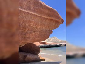 A close-up view of a rock formation on a beach, with no identifiable subjects or activities present.