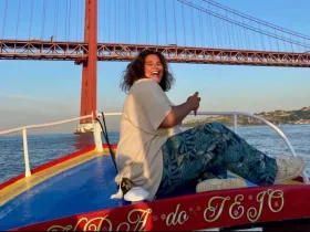 A joyful moment captured on a boat with a stunning bridge in the background, showcasing the beauty of a sunset experience on the water.