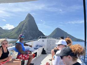 A group enjoys a scenic boat ride near the iconic Pitons in St. Lucia, capturing the essence of adventure and exploration on the water.