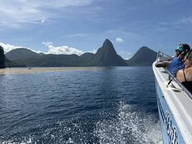 A scenic view of the iconic Pitons in St. Lucia as guests enjoy a boat ride, showcasing the stunning natural beauty of the Caribbean.