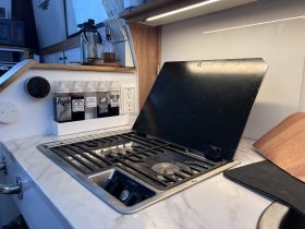A well-equipped boat kitchen featuring a grill and various cooking supplies, perfect for preparing meals while on the water.