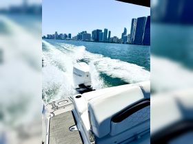 A sleek speedboat cuts through the waters of Miami, showcasing the stunning city skyline in the background — perfect for a day of adventure on the water.