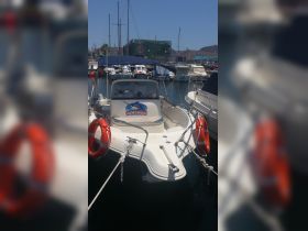A well-maintained fishing boat named 'Tortuga' docked in a marina, showcasing its sleek design and readiness for adventure on the water.