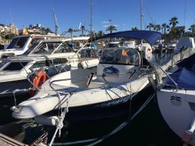 A sleek speedboat docked at the marina, surrounded by other vessels under a clear blue sky — perfect for exploring coastal waters.