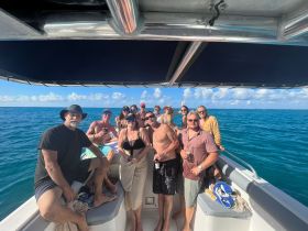 A lively group of friends enjoys a fun day on the water, celebrating together aboard a boat with stunning ocean views.
