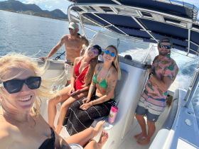 A lively group enjoys a sunny day on a boat, capturing fun moments and smiles while cruising through beautiful waters.