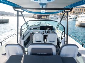 A sleek view of the helm and seating area inside a modern boat, showcasing the stylish design and functional layout perfect for a day on the water.