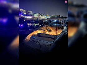 A beautifully lit yacht named 'Enigmas' docked at night in Cascais, showcasing the serene ambiance of the marina.