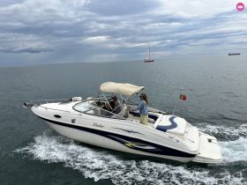 A couple enjoys a scenic ride on a sleek boat, showcasing the thrill of being on the water amidst a beautiful backdrop.