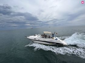 A lively scene of guests enjoying a boat ride on the water, with one person waving cheerfully — perfect for capturing the joy of a day on the sea.