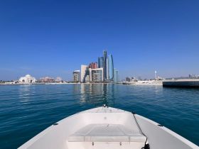 A stunning view from the front of a boat, showcasing the skyline of a vibrant city against a clear blue sky — perfect for exploring urban waterfronts.