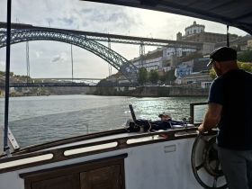 A scenic view from a boat navigating a river, showcasing a stunning bridge and the surrounding architecture, perfect for exploring the beauty of the waterways.