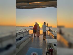 A couple captures a selfie against a stunning sunset backdrop on a boat, creating a memorable moment perfect for romantic getaways or celebrations.
