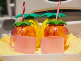 Colorful cocktail cups and a pink mug are displayed on a boat, perfect for enjoying refreshing drinks while cruising on the water.