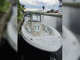 A sleek Robalo center console boat docked along a calm waterway, showcasing its modern design and spacious seating — perfect for fishing or leisurely outings.