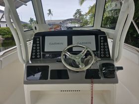 A detailed view of the helm and console of a Robalo boat, showcasing the Garmin navigation system and sleek design, perfect for navigating the waters.