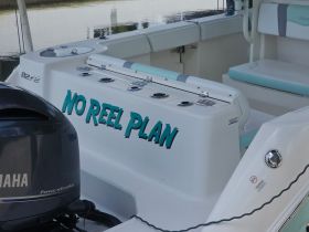 A close-up view of the interior console and seating area of a boat named 'No Reel Plan', showcasing its sleek design and functional layout.
