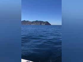 A stunning view of a distant island against a clear blue sky, showcasing the beauty of the ocean — perfect for those seeking scenic boat trips.