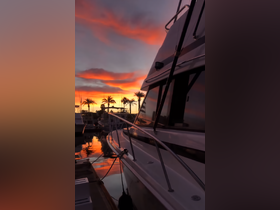 A stunning sunset view of a yacht docked at the marina, reflecting vibrant colors on the water — a perfect scene for evening relaxation.