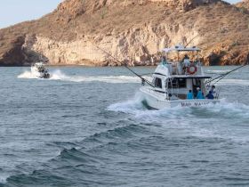 Two fishing boats navigate the ocean waters, showcasing a group adventure on the sea — perfect for fishing enthusiasts and ocean explorers.