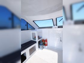 Interior view of a boat cabin featuring seating, storage, and safety equipment, ideal for comfortable cruising and relaxation on the water.