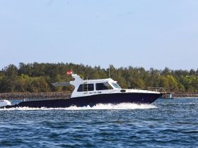 A sleek speedboat navigates through clear waters, showcasing its design and performance on the move.