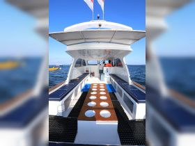 Inside view of a spacious boat cabin featuring seating and helm area, ideal for comfortable outings on the water.