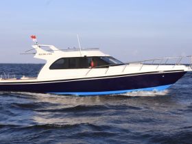 A sleek speedboat cruising through open waters, showcasing its elegant design and vibrant colors — perfect for thrilling adventures on the sea.
