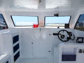The interior of a boat showcasing the helm and console area, perfect for navigating the open waters.