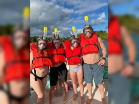 A group of snorkelers, including a child, prepares for an underwater adventure, showcasing the excitement of exploring marine life while safely equipped with life jackets.