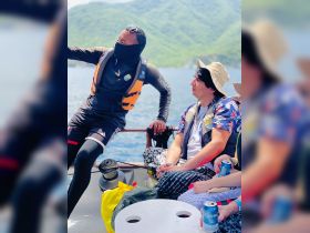 A lively interaction on a boat as a guide engages with guests, creating a memorable experience on the water surrounded by stunning scenery.