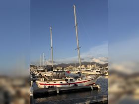 A beautiful yacht docked at the marina, showcasing its elegant design against a clear blue sky — perfect for sailing enthusiasts and boat lovers.